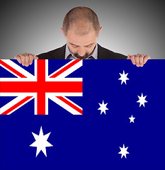 Image showing Smiling businessman holding a big card, flag of Australia