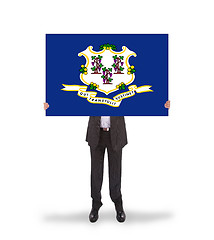 Image showing Smiling businessman holding a big card, flag of Connecticut