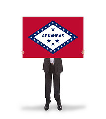 Image showing Smiling businessman holding a big card, flag of Arkansas