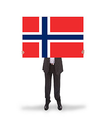 Image showing Smiling businessman holding a big card, flag of Norway