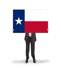 Image showing Smiling businessman holding a big card, flag of Texas