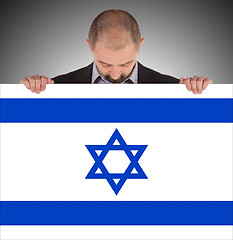 Image showing Smiling businessman holding a big card, flag of Israel