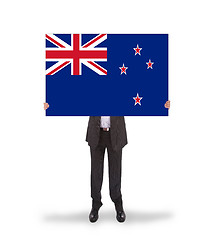 Image showing Smiling businessman holding a big card, flag of New Zealand