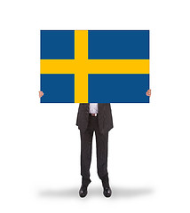 Image showing Smiling businessman holding a big card, flag of Sweden