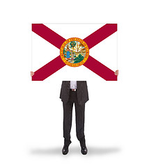 Image showing Smiling businessman holding a big card, flag of Florida