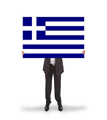 Image showing Smiling businessman holding a big card, flag of Greece