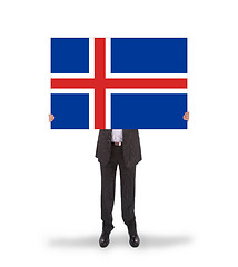 Image showing Smiling businessman holding a big card, flag of Iceland