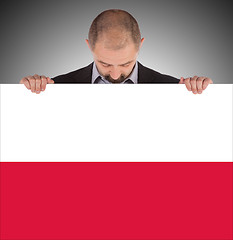 Image showing Smiling businessman holding a big card, flag of Poland
