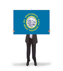 Image showing Smiling businessman holding a big card, flag of South Dakota