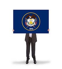 Image showing Smiling businessman holding a big card, flag of Utah