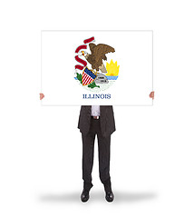 Image showing Smiling businessman holding a big card, flag of Illinois