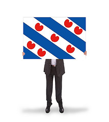 Image showing Smiling businessman holding a big card, flag of the dutch provin