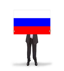 Image showing Smiling businessman holding a big card, flag of Russia