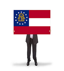 Image showing Smiling businessman holding a big card, flag of Georgia