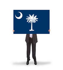 Image showing Smiling businessman holding a big card, flag of South Carolina