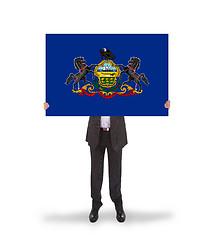 Image showing Smiling businessman holding a big card, flag of Pennsylvania