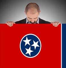 Image showing Smiling businessman holding a big card, flag of Tennessee