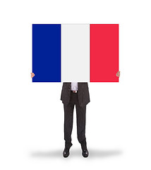 Image showing Smiling businessman holding a big card, flag of France