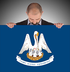 Image showing Smiling businessman holding a big card, flag of Louisiana