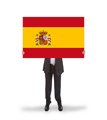 Image showing Smiling businessman holding a big card, flag of Spain