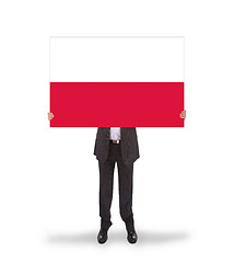 Image showing Smiling businessman holding a big card, flag of Poland