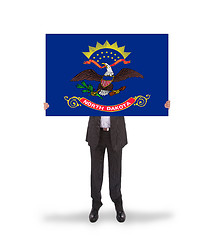 Image showing Smiling businessman holding a big card, flag of North Dakota