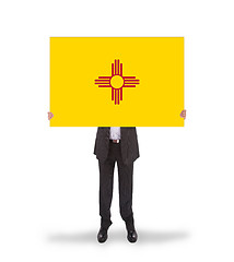 Image showing Smiling businessman holding a big card, flag of New Mexico