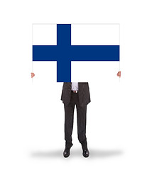 Image showing Smiling businessman holding a big card, flag of Finland