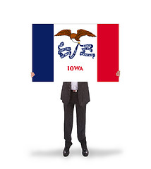 Image showing Smiling businessman holding a big card, flag of Iowa