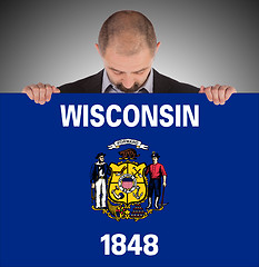 Image showing Smiling businessman holding a big card, flag of Wisconsin