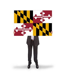 Image showing Smiling businessman holding a big card, flag of Maryland