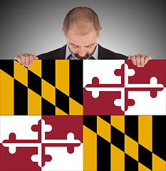 Image showing Smiling businessman holding a big card, flag of Maryland