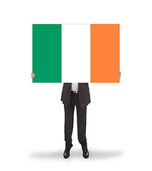 Image showing Smiling businessman holding a big card, flag of Ireland