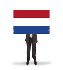 Image showing Smiling businessman holding a big card, flag of the Netherlands