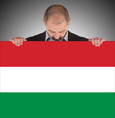 Image showing Smiling businessman holding a big card, flag of Hungary