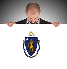 Image showing Smiling businessman holding a big card, flag of Massachusetts