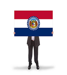 Image showing Smiling businessman holding a big card, flag of Missouri