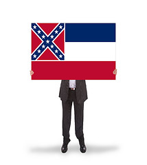 Image showing Smiling businessman holding a big card, flag of Mississippi