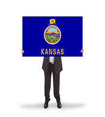 Image showing Smiling businessman holding a big card, flag of Kansas