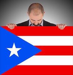 Image showing Smiling businessman holding a big card, flag of Puerto Rico