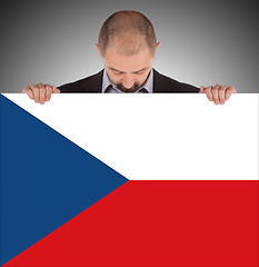 Image showing Smiling businessman holding a big card, flag of the Czech Republ