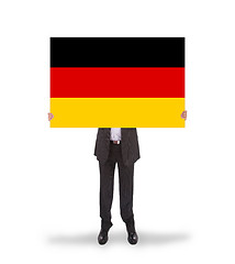 Image showing Smiling businessman holding a big card, flag of Germany