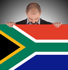 Image showing Smiling businessman holding a big card, flag of South Africa