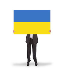 Image showing Smiling businessman holding a big card, flag of Ukraine