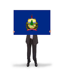 Image showing Smiling businessman holding a big card, flag of Vermont