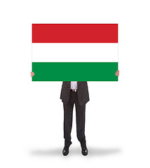 Image showing Smiling businessman holding a big card, flag of Hungary