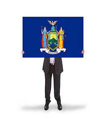 Image showing Smiling businessman holding a big card, flag of New York