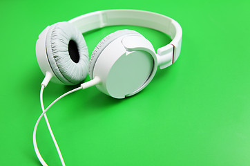 Image showing White headphone with green background