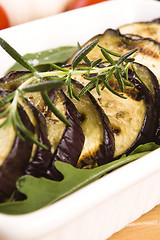 Image showing Grilled eggplant slices on a plate with fresh rosemary