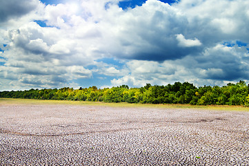 Image showing sun and clouds over cracked field